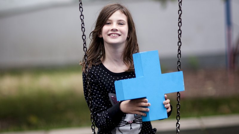 Junges Mädchen auf Schaukel mit einem blauem Erasmus Logo